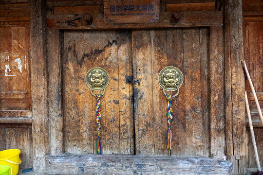 Weathered wooden door of the monastic college kitchen stands at Bongya monastery, Qinghai Province, Mosele, China
