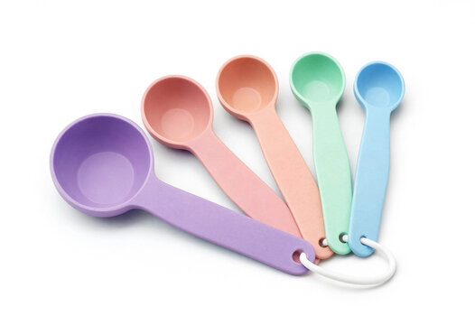 Colorful pastel measuring spoons isolated on white background with kitchen utensil