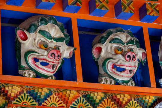 Carved guardian masks decorate a wooden beam at Bongya monastery, Qinghai Province, Mosele, China