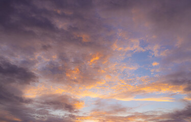 Fototapeta premium Vibrant Sunset Sky Panorama with Colorful Orange Pink and Blue Clouds,A panoramic photograph capturing a vibrant sunset sky filled with wispy cirrus clouds illuminated in golden yellow, orange, pink, 