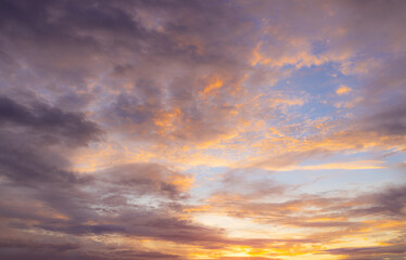 Fototapeta premium Vibrant Sunset Sky Panorama with Colorful Orange Pink and Blue Clouds,A panoramic photograph capturing a vibrant sunset sky filled with wispy cirrus clouds illuminated in golden yellow, orange, pink, 