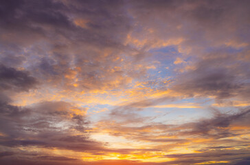 Obraz premium Vibrant Sunset Sky Panorama with Colorful Orange Pink and Blue Clouds,A panoramic photograph capturing a vibrant sunset sky filled with wispy cirrus clouds illuminated in golden yellow, orange, pink, 