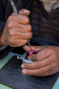 Craftsman carves a traditional Chinese stamp with a hand tool, Gansu Province, Linxia, China