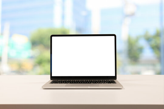 close up isolated on blank white screen display of laptop computer on table inside office room for add content of design banner , website or template or online shopping e-commerce concept