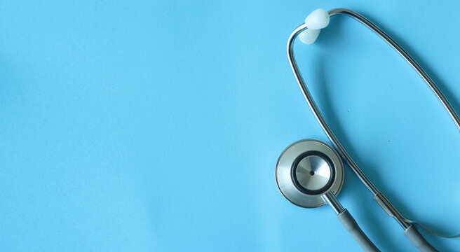Close- up stethoscope and pen on blue background. Medical equipment for healthcare in hospital and clinic for diagnosis, treatment and health examination concept