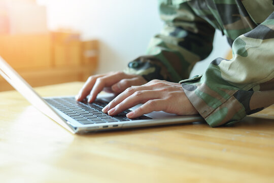 close up soldier man hand type o laptop to check security system of access data in private monitoring room with virtual icon for military operation control and command concept