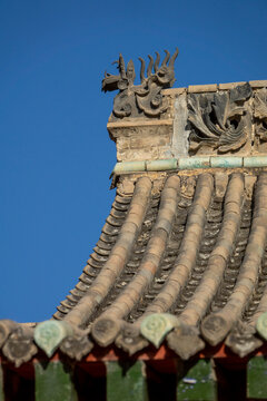 Curved roof tiles meet a dragon ornament at Dong Gong Guan mansion, Gansu Province, Linxia, China