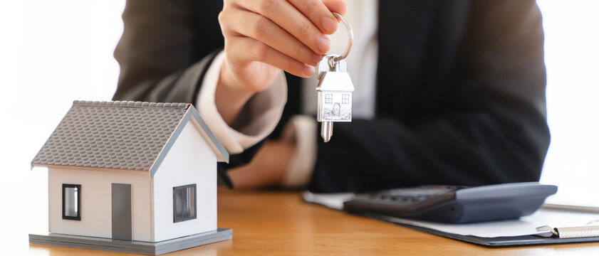Realtor agent giving a key of apartment to new owner after signed lease agreement.