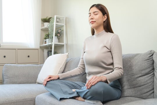 Women practice her mindfulness by meditation at home.
