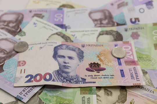 Ukrainian hryvnia banknotes arranged as physical paper currency, displaying the distinctive designs, colors, denominations, portraits, architectural motifs, national symbols, and printed details