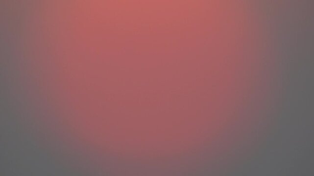 Sunset, sun disc, haze revealing bright orange orb behind thick gray clouds during dramatic close-up.