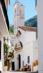 Obraz premium San Miguel Church and whitewashed street in Istán, Málaga, Spain