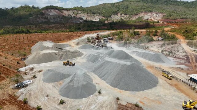 Heavy machinery crushing stones into gravel at an industrial mining site in South Kalimantan