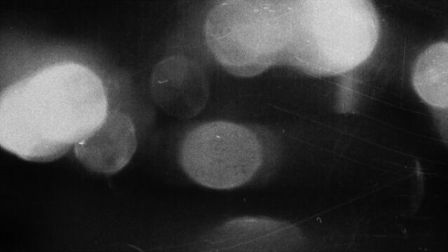 Abstract black and white background with glowing soft light circles and vintage film grain texture effect