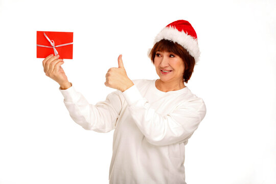 Senior woman giving thumbs up with christmas gift card