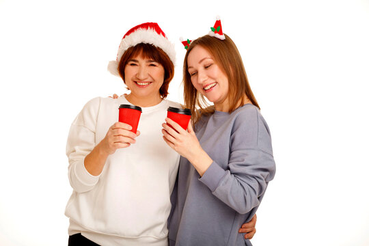 Women celebrating christmas with coffee in santa hats