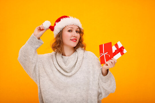 Woman wearing santa hat holding christmas gift cards