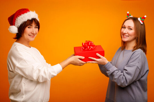 Mother and daughter exchanging christmas gift, celebrating holiday joy