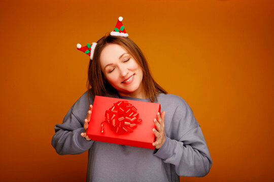 Woman receiving christmas gift feeling happiness and surprise