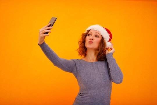 Woman wearing santa hat taking christmas selfie