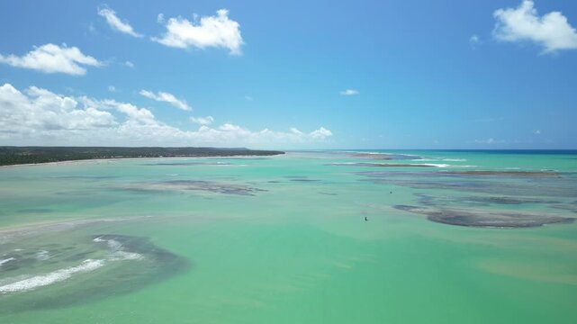 Vista a&eacute;rea de &aacute;guas turquesa e recifes na costa de Alagoas, paisagem paradis&iacute;aca de drone durante viagem pelo litoral nordestino brasileiro