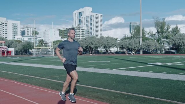 Morning run. Man running at racetrack outdoor. Runner sprinter with incredible speed. Sport runner completing a marathon. Sport training. Man sportsman running for exercise. Energetic morning