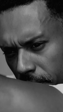 African American man looking down with intense contemplation in dramatic black and white