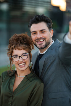 Two business colleagues smiling for a selfie, showing partnership and success