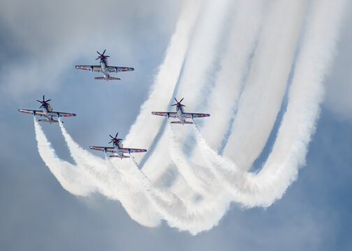 Aerial view of four aerobatic aircraft of the Indonesia Jupiter KT-1B Wongbee Trainers acrobatic team performing a formation flight with smoke trails