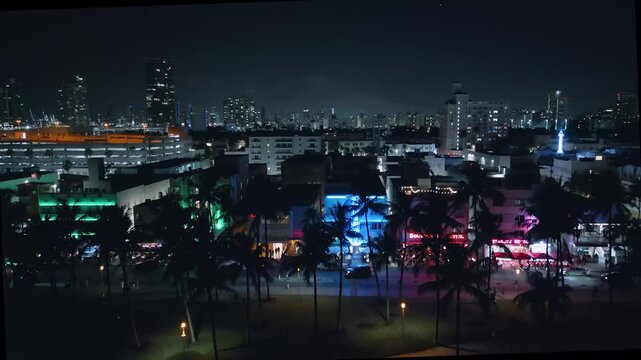 Miami Beach's electric Collins Avenue pulses with neon in this nighttime aerial sequence