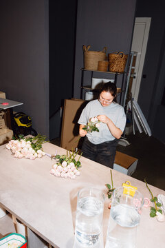 Florist Preparing Fresh Roses for Arrangement