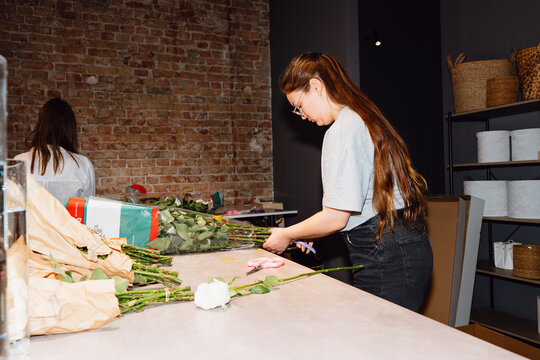 Florist Preparing Fresh Roses for Arrangement