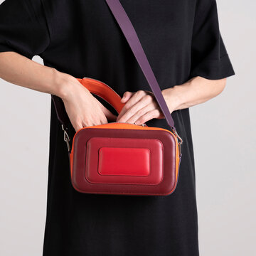 Hands Opening Red Leather Crossbody Bag
