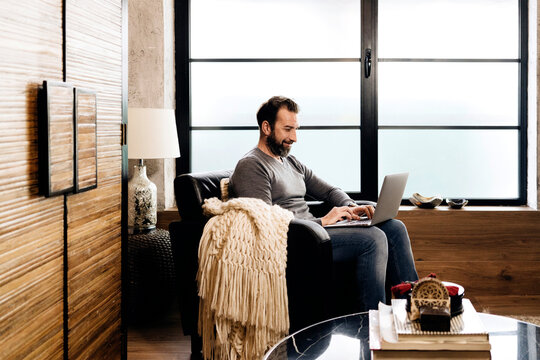 Professional using laptop for remote work at home