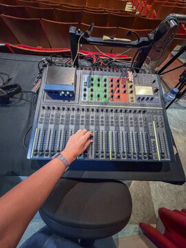 Sound engineer operating mixing console inside theater