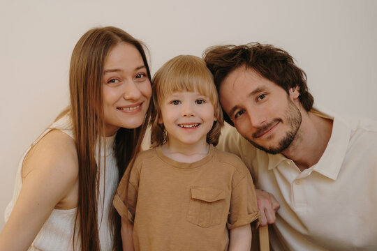 Happy young family with a little son smiling at the camera together