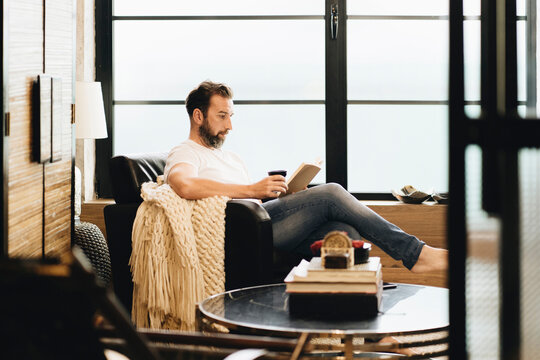 Person reading book relaxing at home