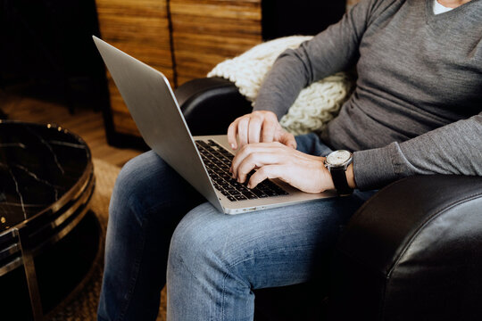 Person typing on laptop keyboard at home office