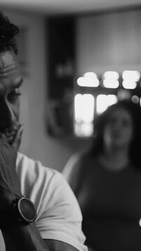 African American husband looking away while wife talks during kitchen argument