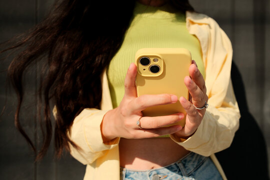 Close up crop of faceless woman using mobile phone