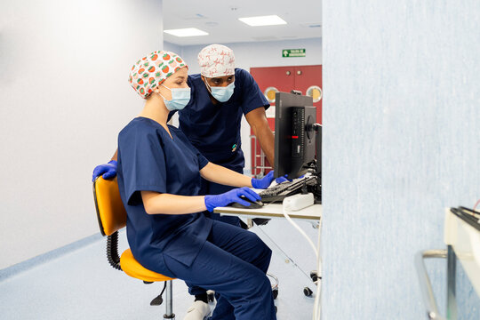 Medical team collaborating on computer in clinic