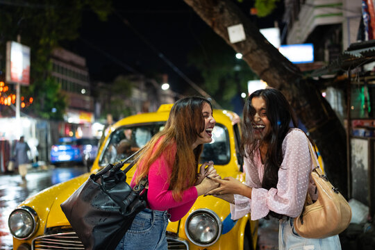 Two happy young Indian woman met in a city