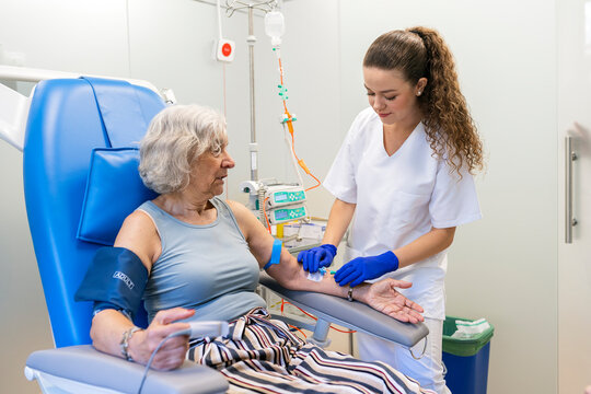 Nurse inserting iv line for senior patient treatment