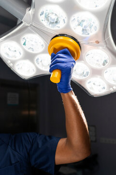 Surgeon hand adjusting surgical light in operating room