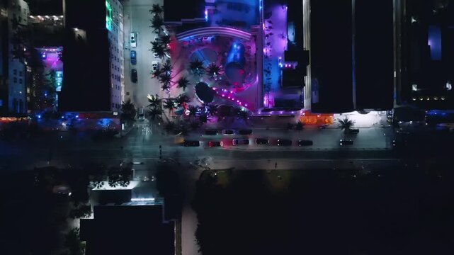 Bright urban waterfront glows with purple and cyan neon in this sweeping Miami Beach aerial sequence