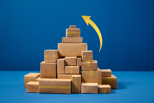 Stack of cardboard boxes with a yellow arrow indicating growth