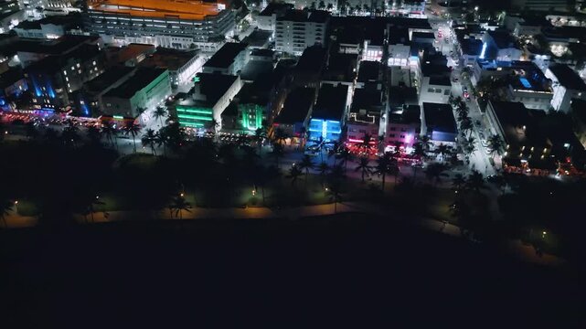Neon-lit Collins Avenue unfolds in a mesmerizing aerial night glide through Miami Beach