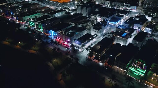 Electric colors stream across Collins Avenue in this nighttime Miami Beach aerial journey