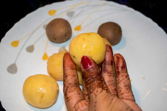 hand holding fresh boiled potato at kitchen.