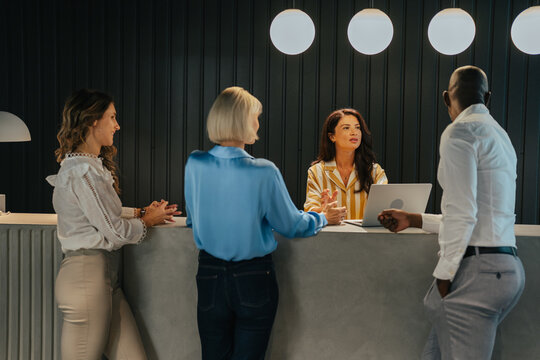 Diverse group of business people interacting at reception desk